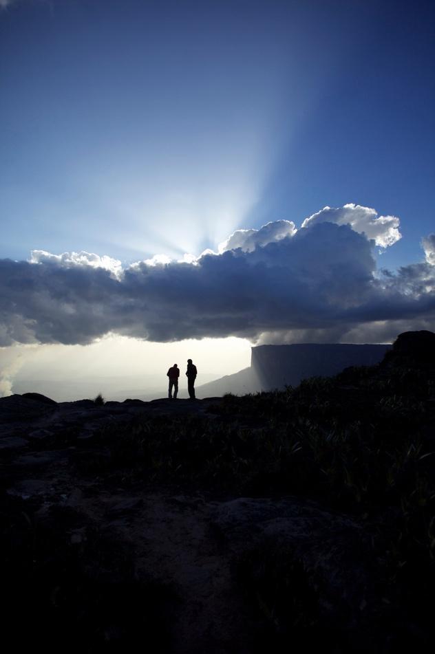 Zwei Menschen im Gegenlicht auf einem Hochplateau